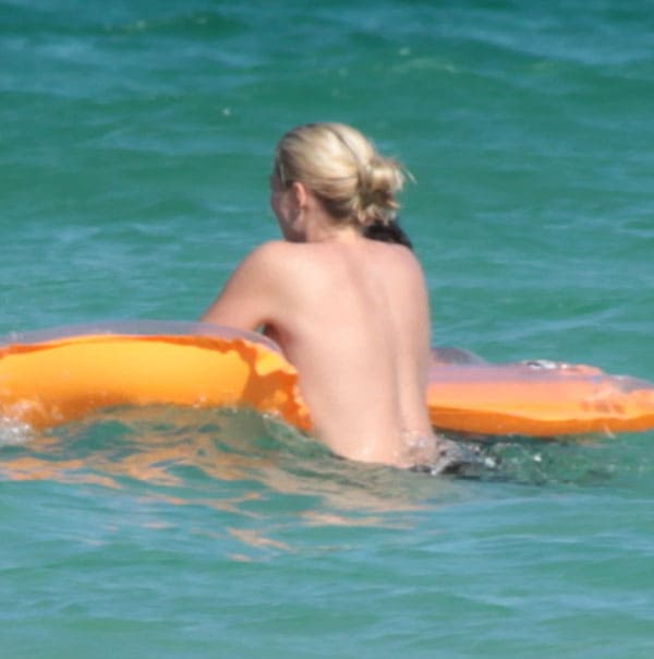 Женщина с голыми сиськами купается в море фото