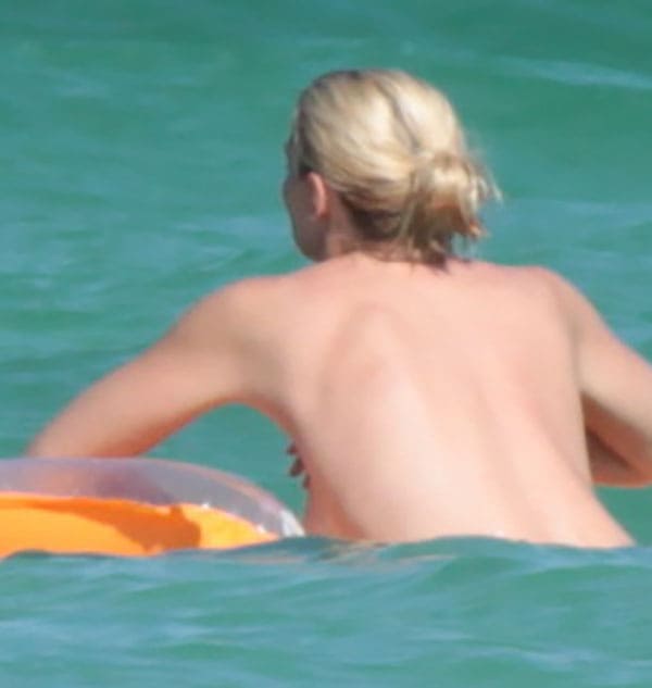 Женщина с голыми сиськами купается в море фото