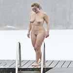 Голая женщина купается зимой под снегопадом